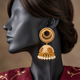 Rangoli ER-175 Champagne jhumka earring close-up on a charcoal mannequin with swept-back dark hair