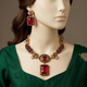 Jharokha Ruby necklace set on an ivory mannequin in emerald silk formalwear