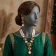 Noor-e-Jahan Ruby necklace set on a mannequin in emerald silk wedding formalwear
